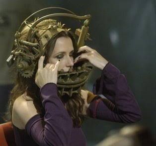 a woman wearing a steampunk headpiece talking on the phone