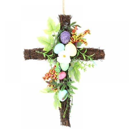 a cross with flowers and leaves hanging from it's side on a white background