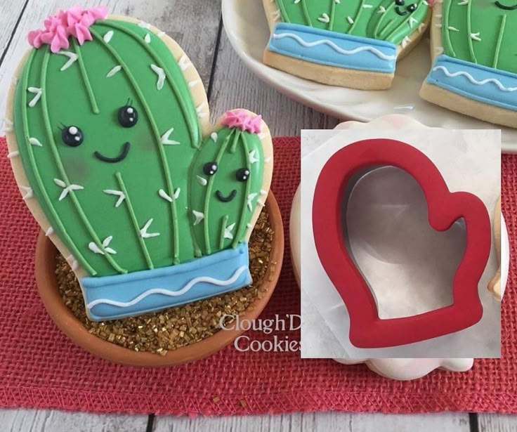 decorated cookies in the shape of cactus and heart shaped cookie cutters