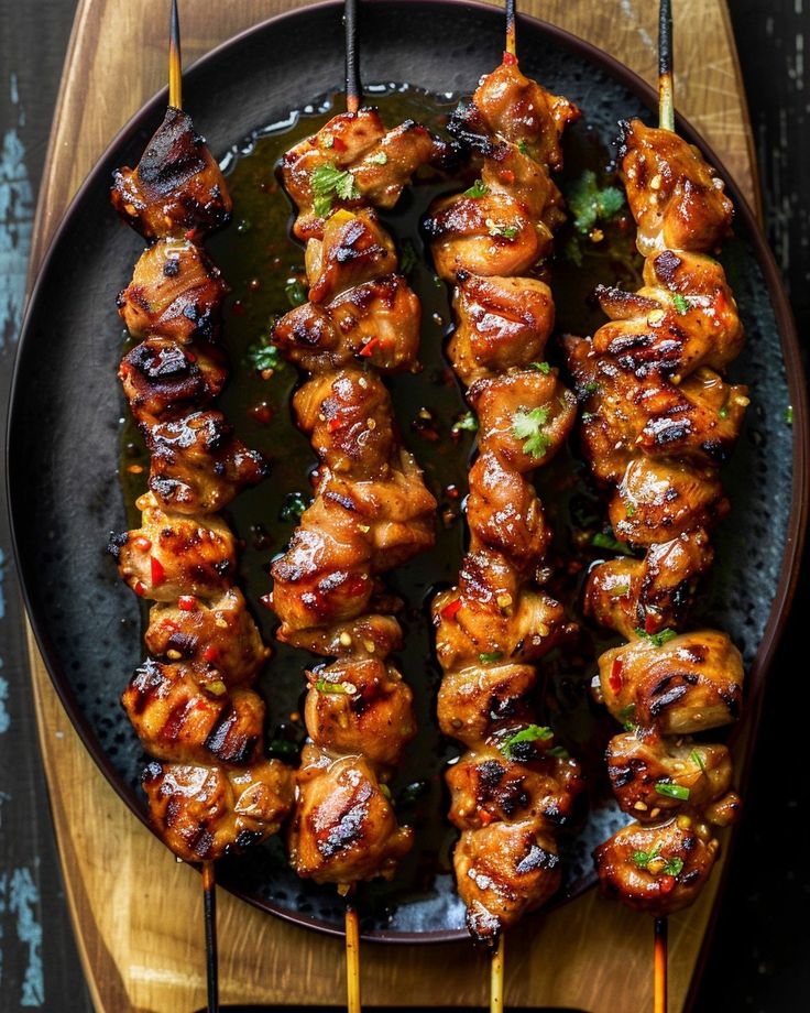 chicken skewers on a plate with toothpicks in them and garnished with cilantro