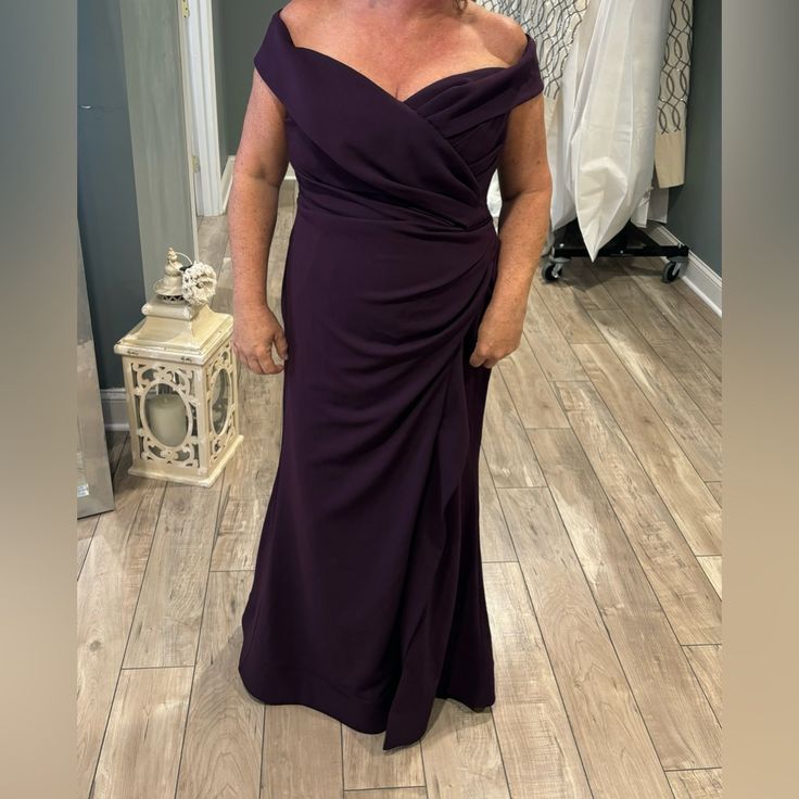 a woman in a purple dress posing for the camera with her hands on her hips