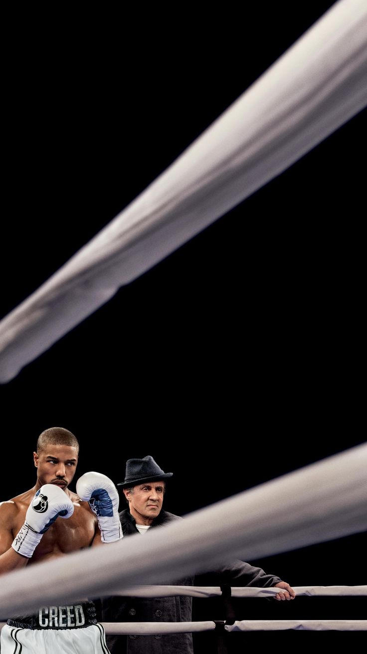 two men standing next to each other in a boxing ring with their hands on the ropes