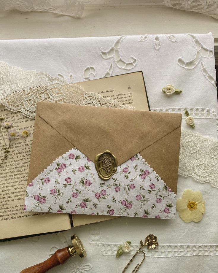 an envelope with a wax stamp on it sitting next to some paper and other items