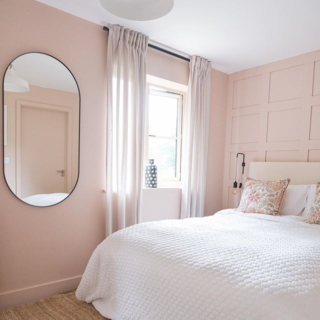 a bedroom with pink walls and white bedding