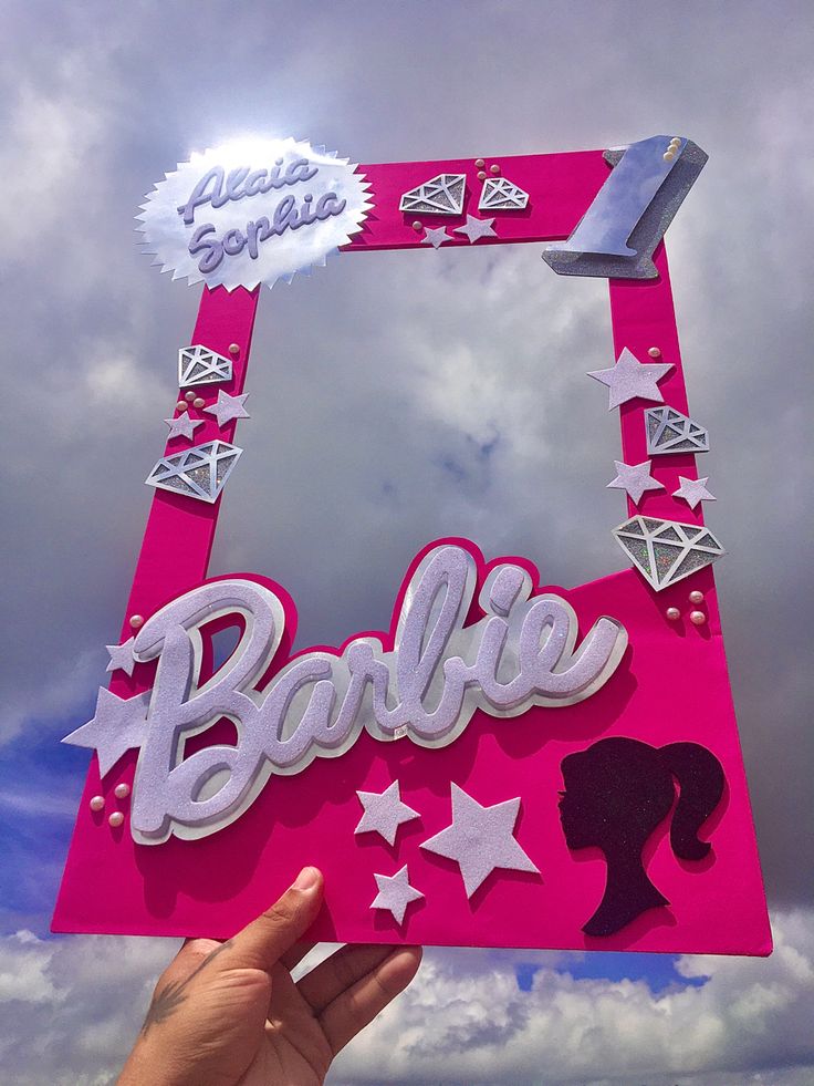 someone is holding up a barbie sign in front of the sky with stars and diamonds