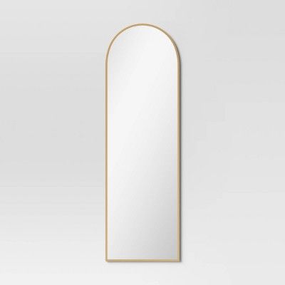 an arched mirror on a white wall