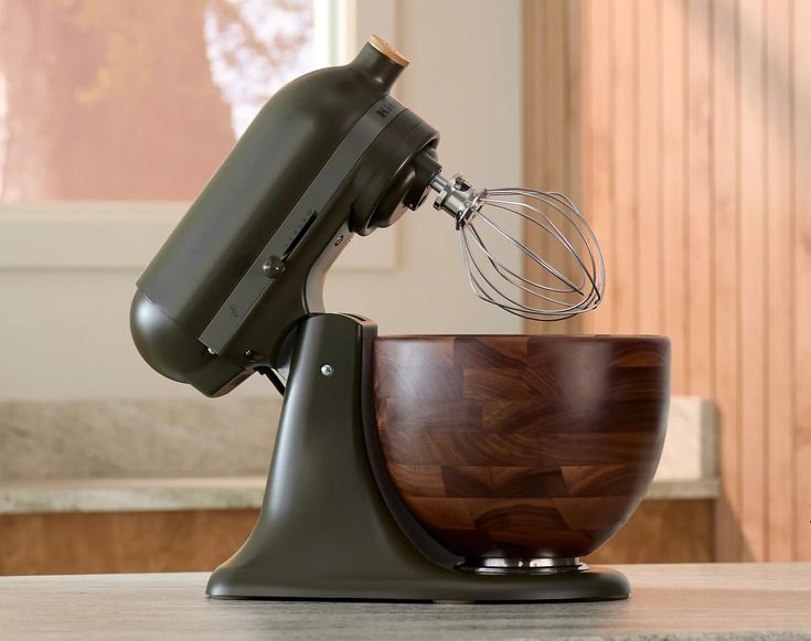 an electric mixer with a wooden bowl on it