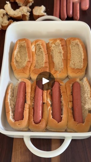 several hot dogs in buns with mustard on them