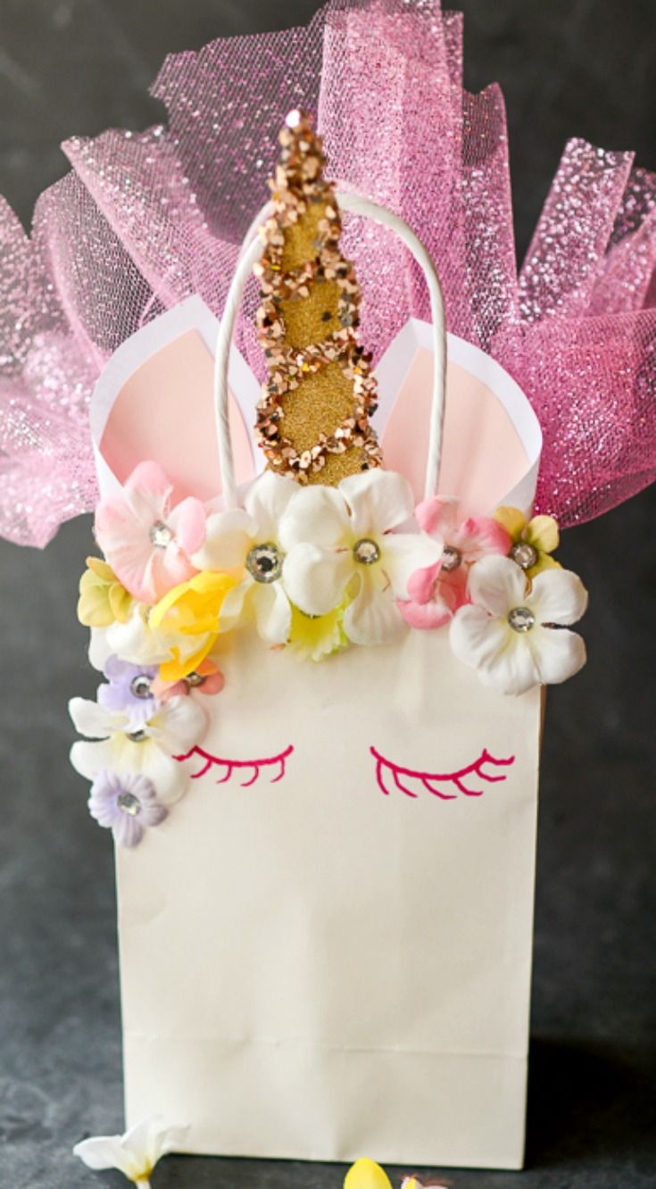 a small white bag with pink and yellow flowers in it, sitting on a black surface