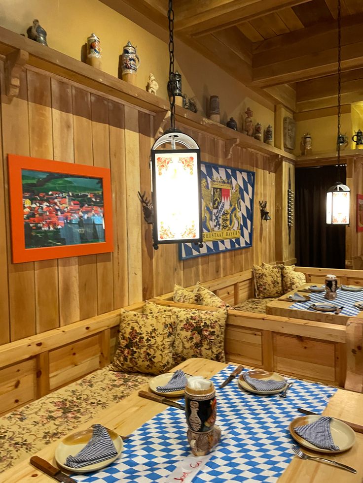 a dining room with wooden walls and blue checkered table cloths on the tables