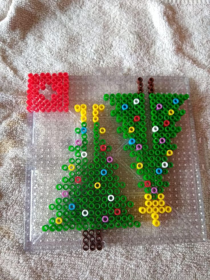 a plastic tray with beads on it and a christmas tree made out of legos