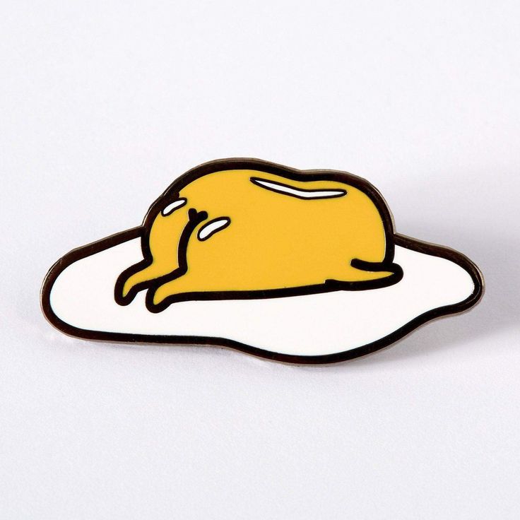 a yellow and white egg laying on top of a black and white lapel pin