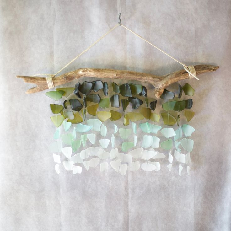 a piece of driftwood with sea glass hanging from it