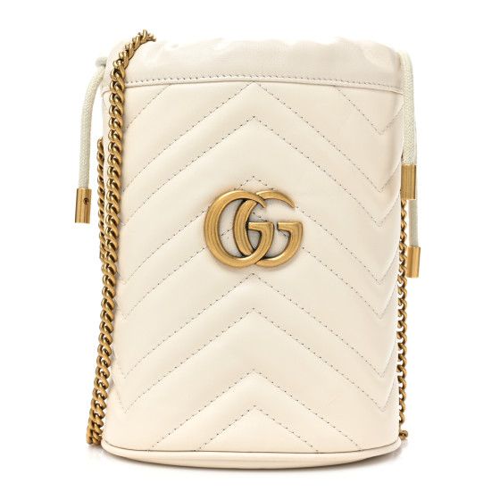 This is an authentic GUCCI Calfskin Matelasse Mini GG Marmont 2.0 Bucket Bag in White. This bucket bag is crafted of white calfskin leather with chevron stitching. The bag features a top cinch cord, an aged chain shoulder strap, and an aged gold GG logo on the front. The top opens to a beige microfiberinterior with leather card slots. White Gucci Bag, White Bucket Bag, Gucci Bucket Bag, Gucci Gg Marmont Mini, Gg Marmont Mini, Crafted Bag, Bucket Handbags, Mini Bucket Bags, Mini Bucket