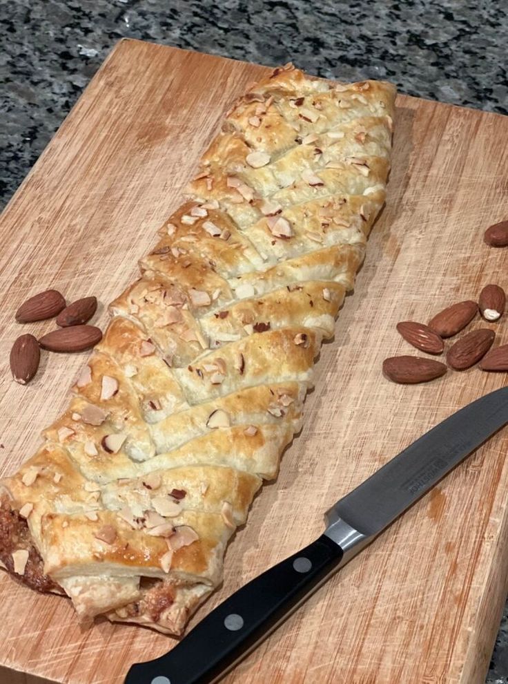 a piece of bread sitting on top of a wooden cutting board next to a knife