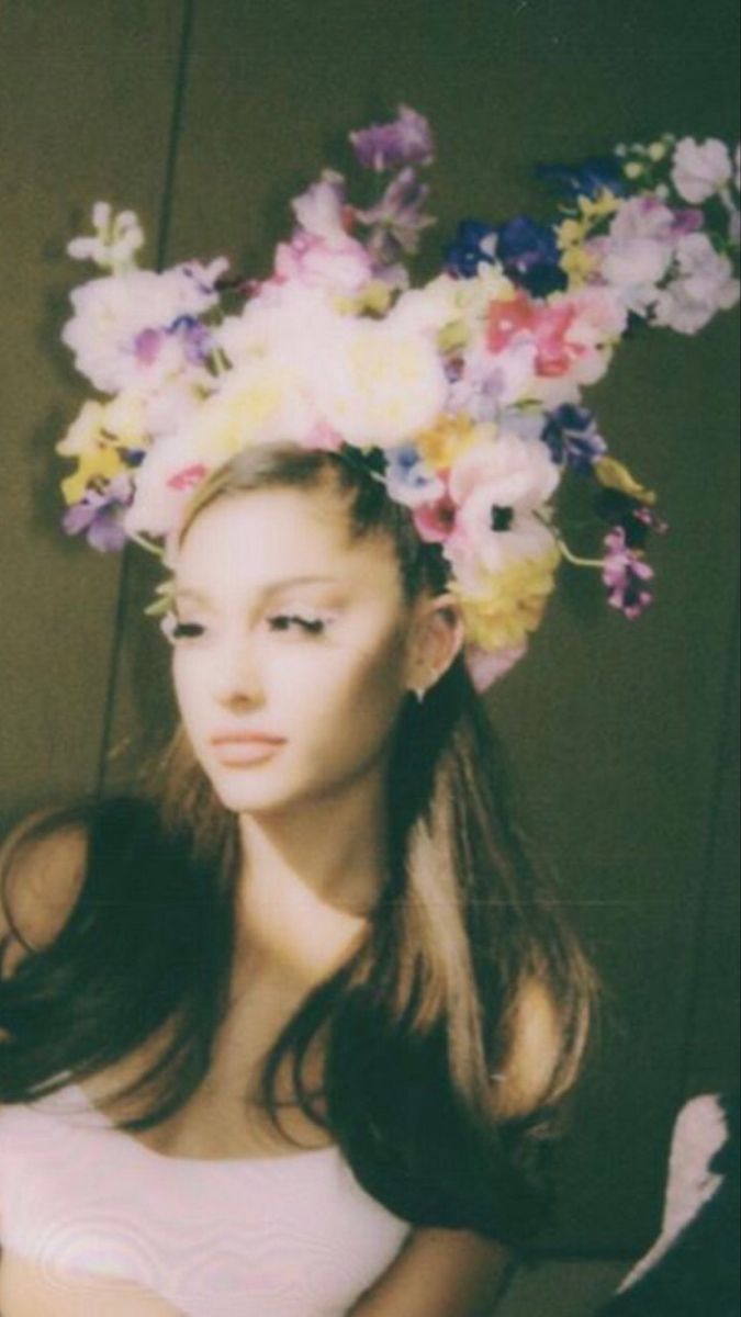 a woman with flowers in her hair wearing a bra top and panties is posing for the camera