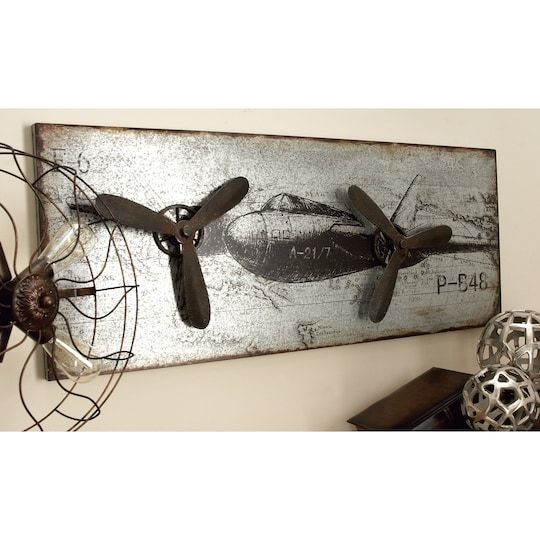 an old airplane is hanging on the wall next to some metal balls and other items