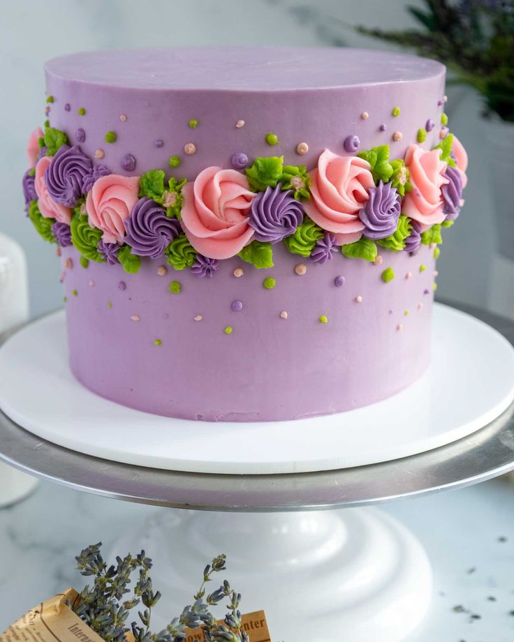 a purple cake with pink and green flowers on it