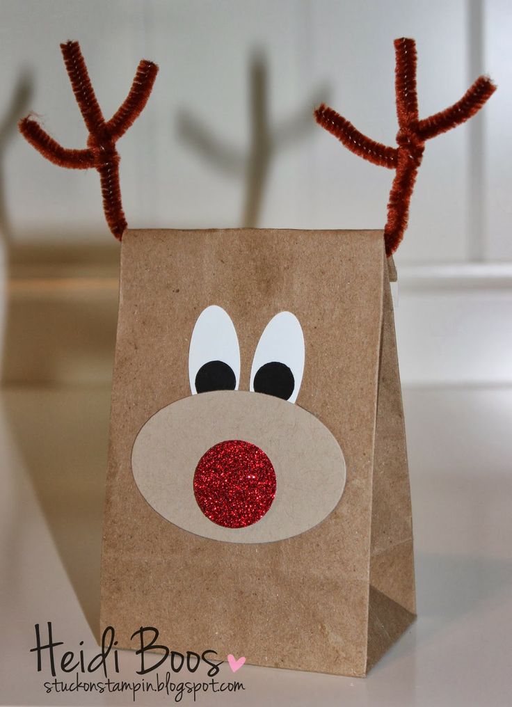 a brown paper bag with reindeer antlers on it's head and eyes, sitting on a table