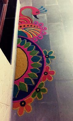 an artisticly designed rug on the floor in front of a door with flowers and peacocks painted on it