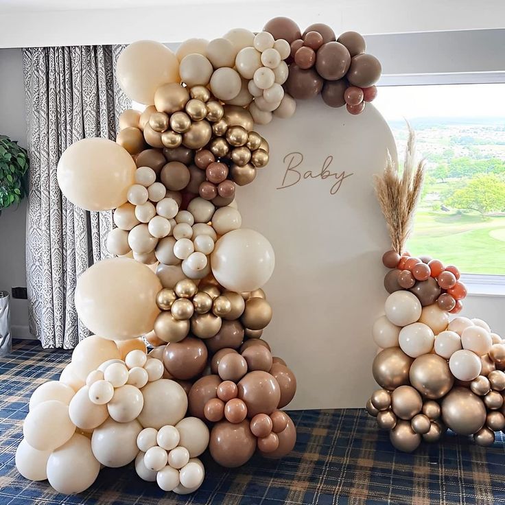 a wreath made out of balloons on top of a table in front of a window