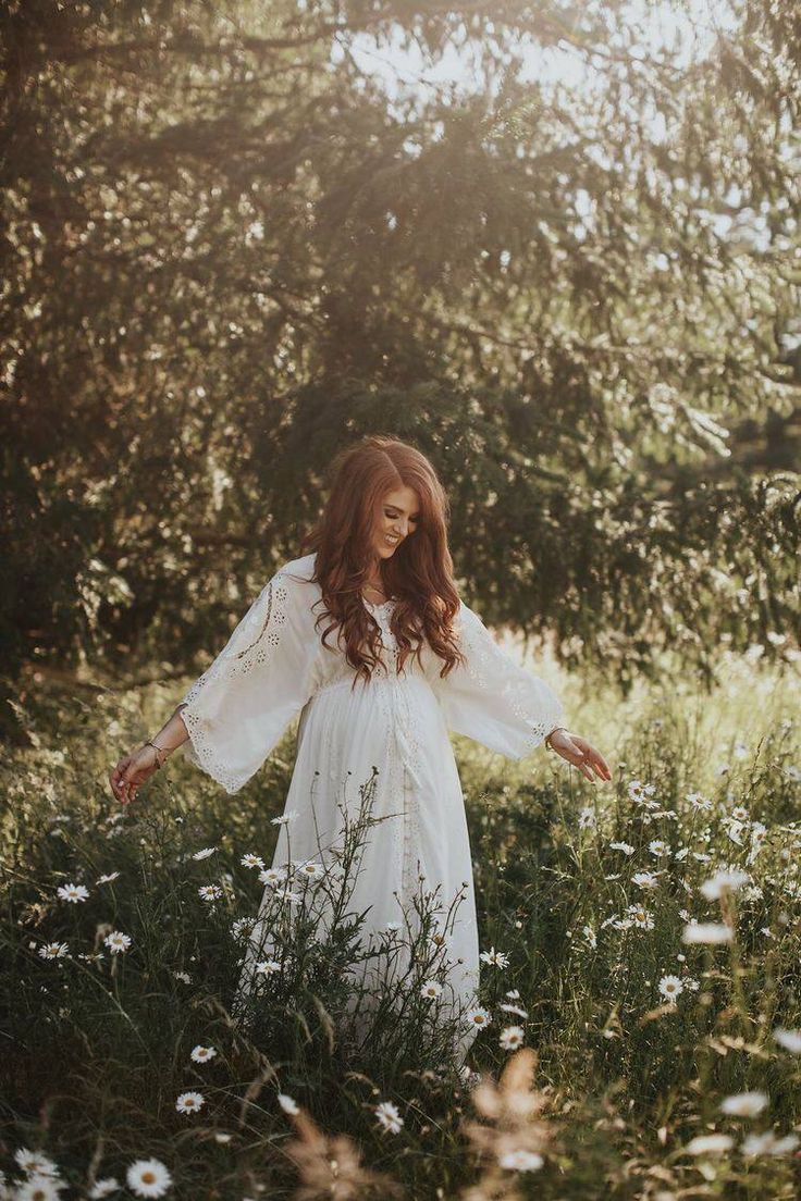 a woman standing in the middle of a field