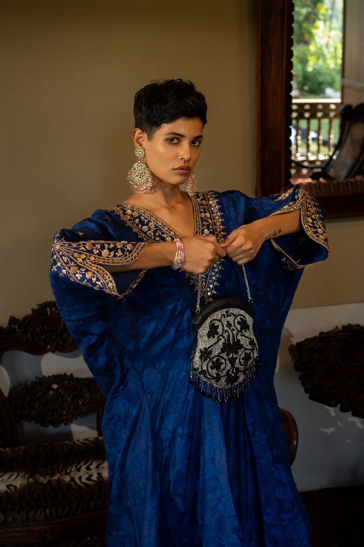 Editor's Note Featuring a deep blue self-woven kaftan with hand embroidery on yoke and cuffs. This elegant piece comes embellished with careful antique embroidery detailing. Color: Blue Fabric: Russian jacquard Component: Kaftan Fit: Relaxed Occasion: Resort and evening wear Care: Dry Clean Only About the Designer Paulmi & Harsh is a luxury prêt label inspired by beautiful botanicals. Paulmi & Harsh design strong, feminine silhouettes with prints and delicate detailing, fusing 1950’s fashion wit Transitional Festive Kaftan With Resham Embroidery, Festive Transitional Kaftan With Resham Embroidery, Traditional Silk Kaftan For Eid, Festive Dabka Work Kaftan Tunic, Festive Kaftan With Intricate Embroidery In Traditional Drape, Festive Kaftan With Embroidered Neckline, Festive Kaftan With Intricate Embroidery And Traditional Drape, Embroidered Traditional Drape For Evening, Silk Kaftan With Zari Work For Evening