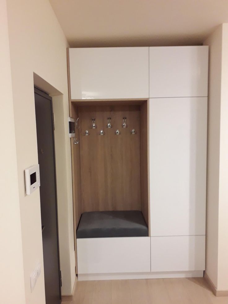 an empty room with white cabinets and black bench