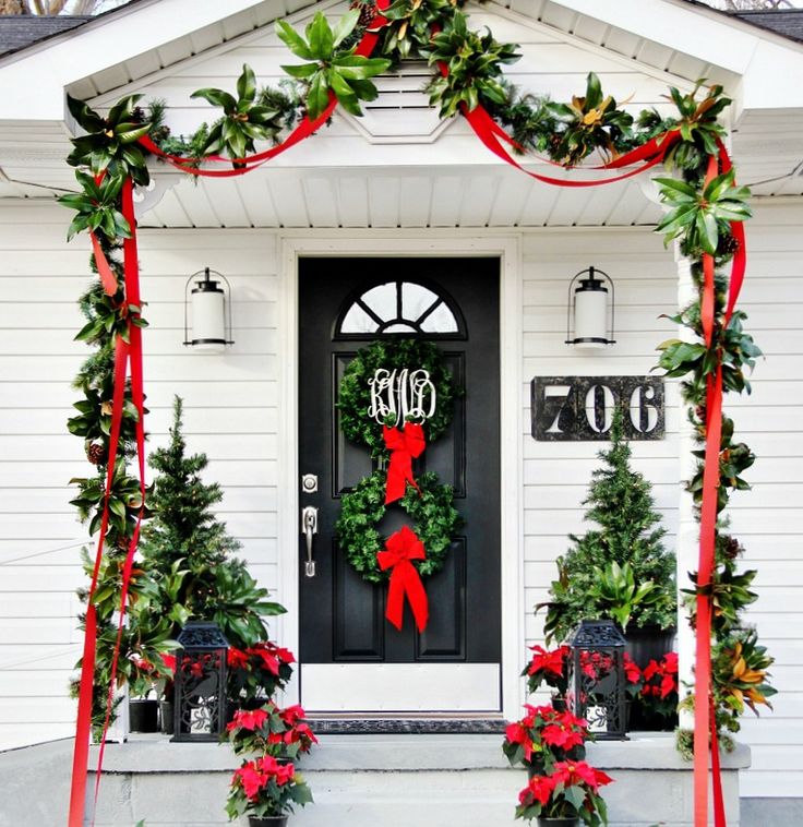 the front door is decorated with christmas wreaths