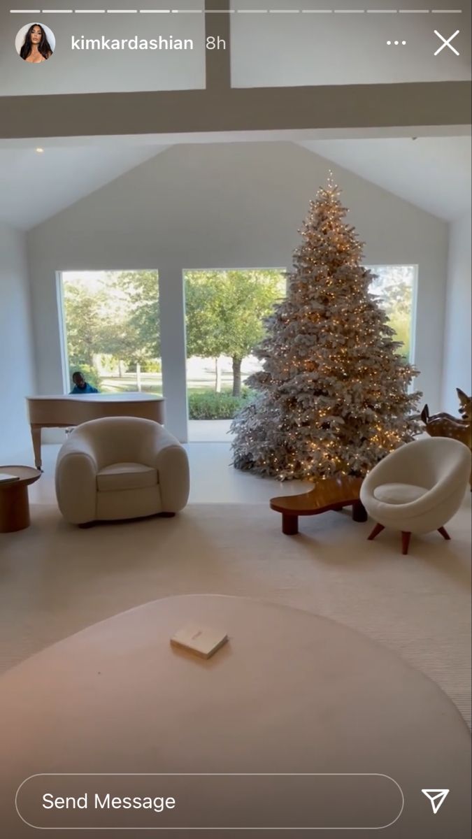 a living room filled with furniture and a christmas tree in the middle of the room