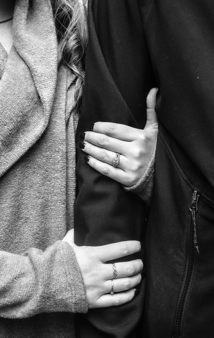 two people standing next to each other with their hands wrapped around the couple's shoulders