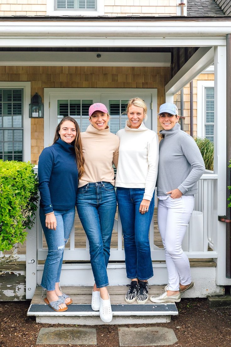 three women standing on steps in front of a house with their arms around each other