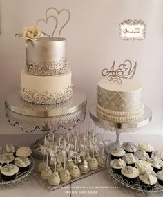 a table topped with three tiered cakes and cupcakes