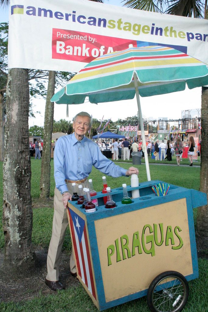 a man standing next to a cart filled with drinks