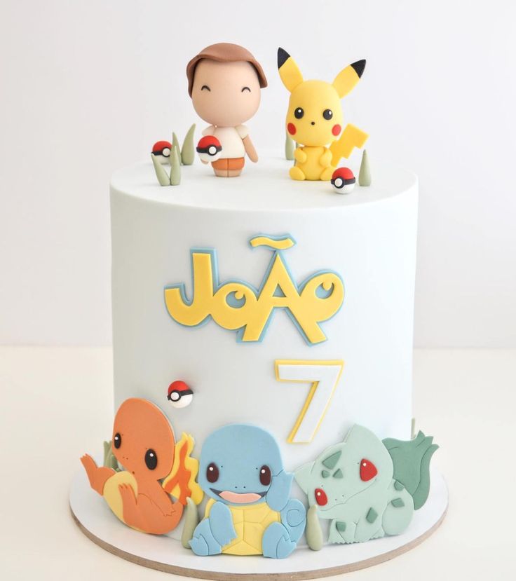 a pokemon themed birthday cake with figurines on top