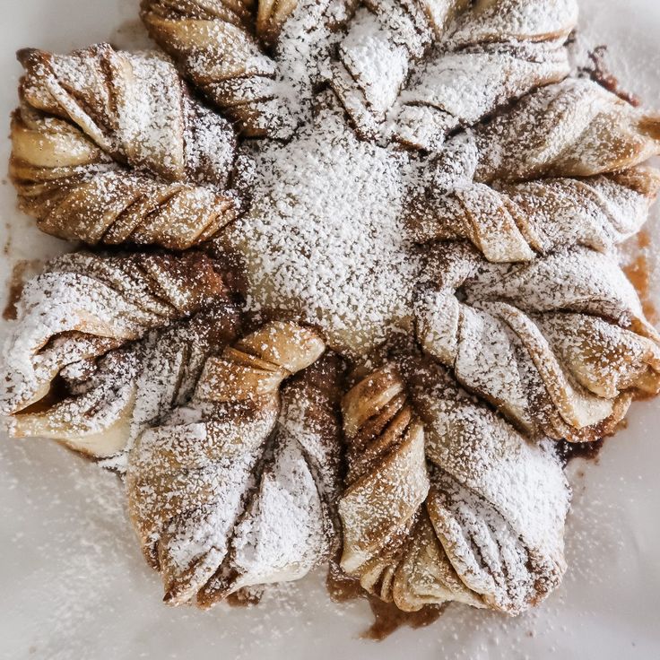 a white plate topped with powdered sugar covered pastries