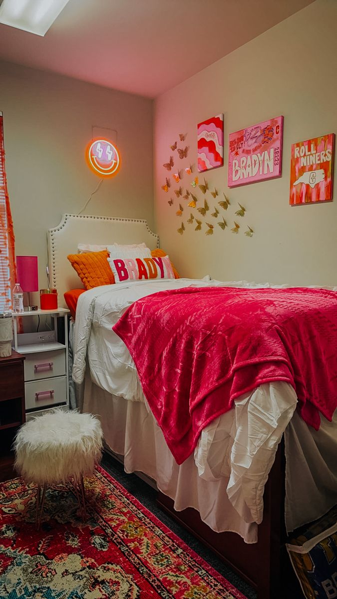 a bedroom with pink and white decor on the walls, carpeting and bedding