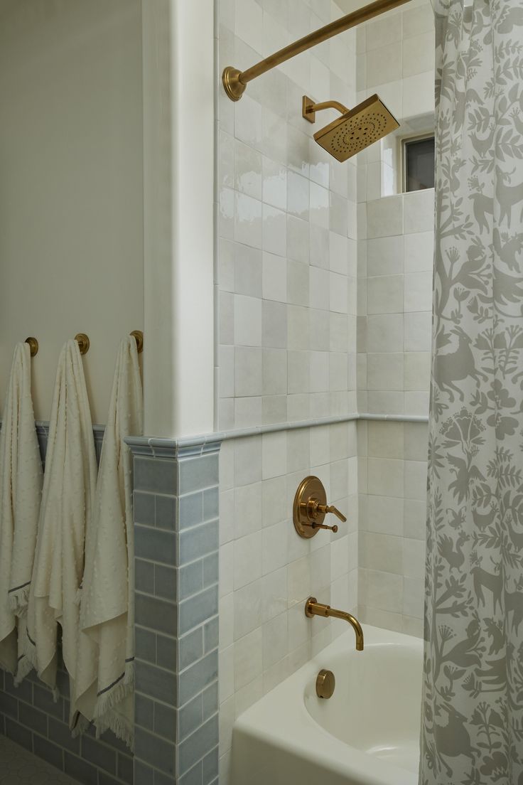 a bathroom with towels hanging on the wall and a bathtub in the shower area