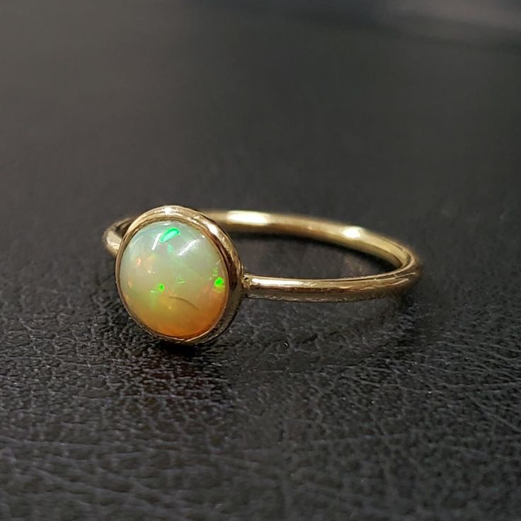 1. ethiopian opal 14k gold ring 2. made to order  3. gemstone - ethiopian opal 4. jewelry type - gold ring 5. total weight - 1.327 gram approx 6. opal weight - 0.93 cartas 7. gold weight - 1.140 gram approx 8. opal size - 7 mm 9. gold purity - 14k 10. handmade items 11. band size - 1.50 mm 12. high polished 13. aaa quality ring  14. stackable ring 15. 1 quantity available 16. ready to dispatch in 1 -2 days. 17. rare size / rare fire 14k Gold Opal Ring, Gold Opal Ring, Ethiopian Opal Ring, Ring Bezel, Opal Ring Gold, 14k Gold Ring, Opal Ring, Stackable Rings, Opal Rings