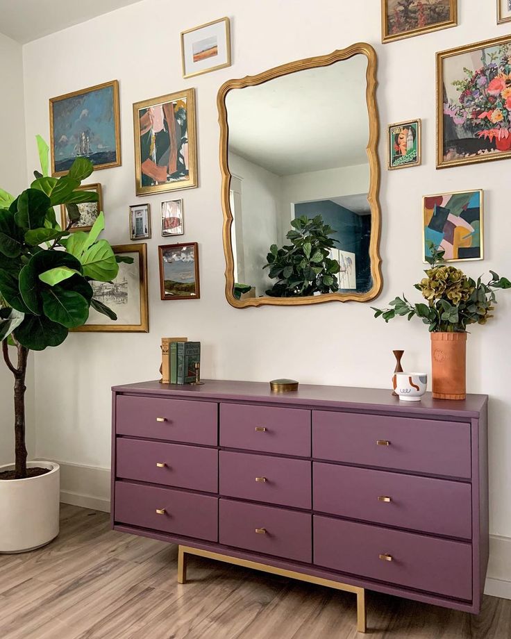 a purple dresser sitting in front of a mirror on top of a hard wood floor