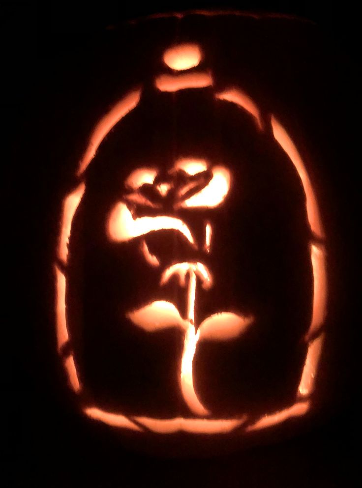 a carved pumpkin with an image of a person holding a flower in it's mouth