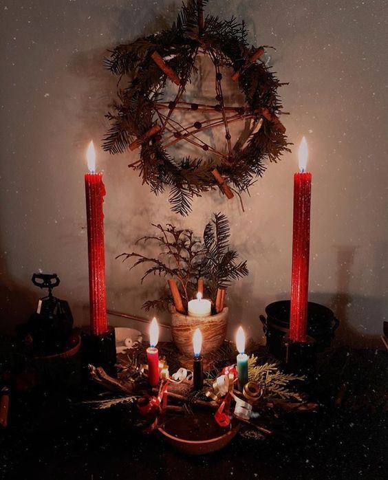 a table topped with candles next to a wreath