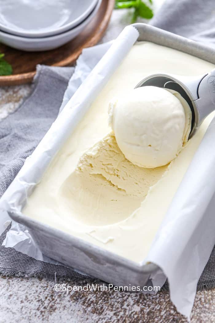 a scoop of ice cream in a pan on top of a towel next to a spoon