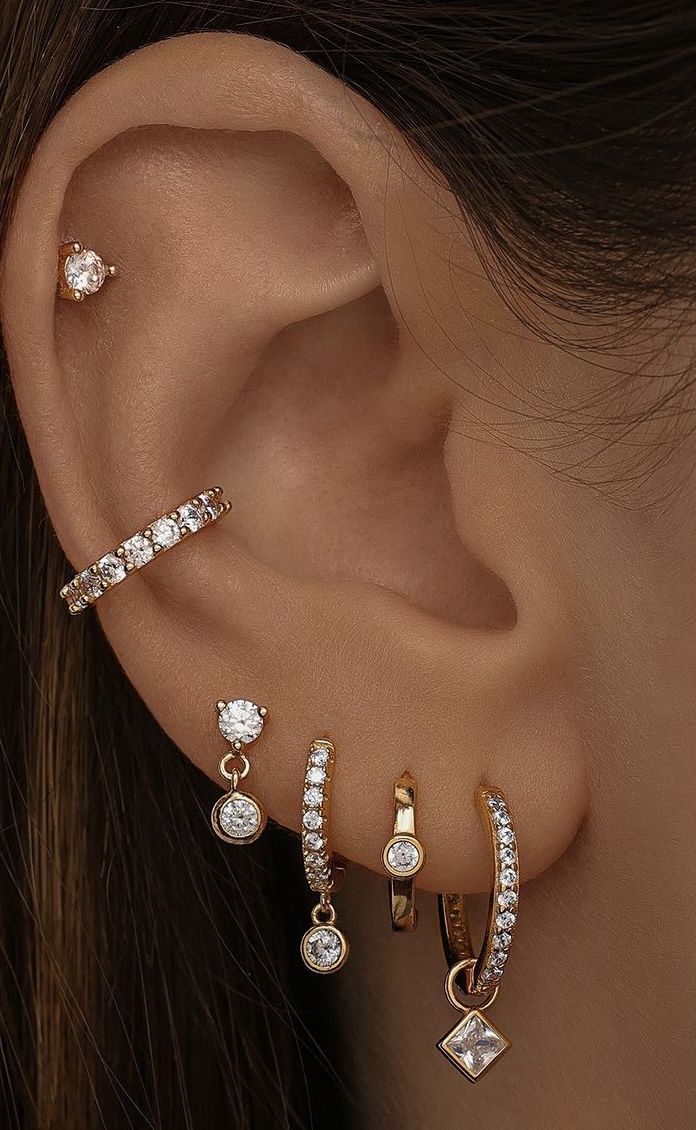 three different types of ear piercings in gold, silver and white colors with diamonds