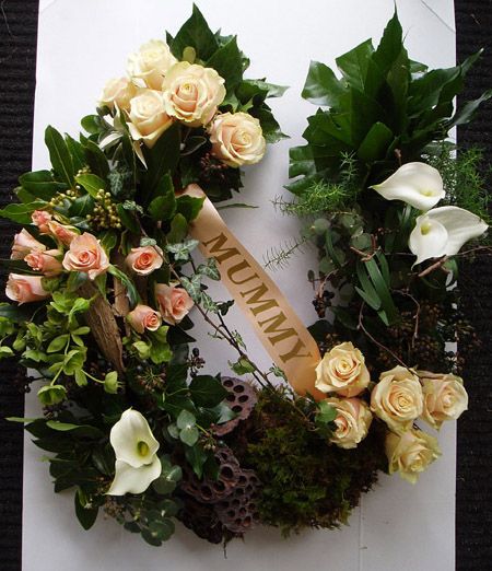 an arrangement of flowers and greenery laid out on top of a piece of paper