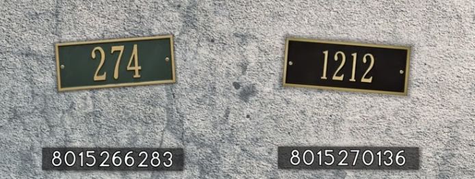 two black and gold plates with numbers are on the side of a gray stone wall