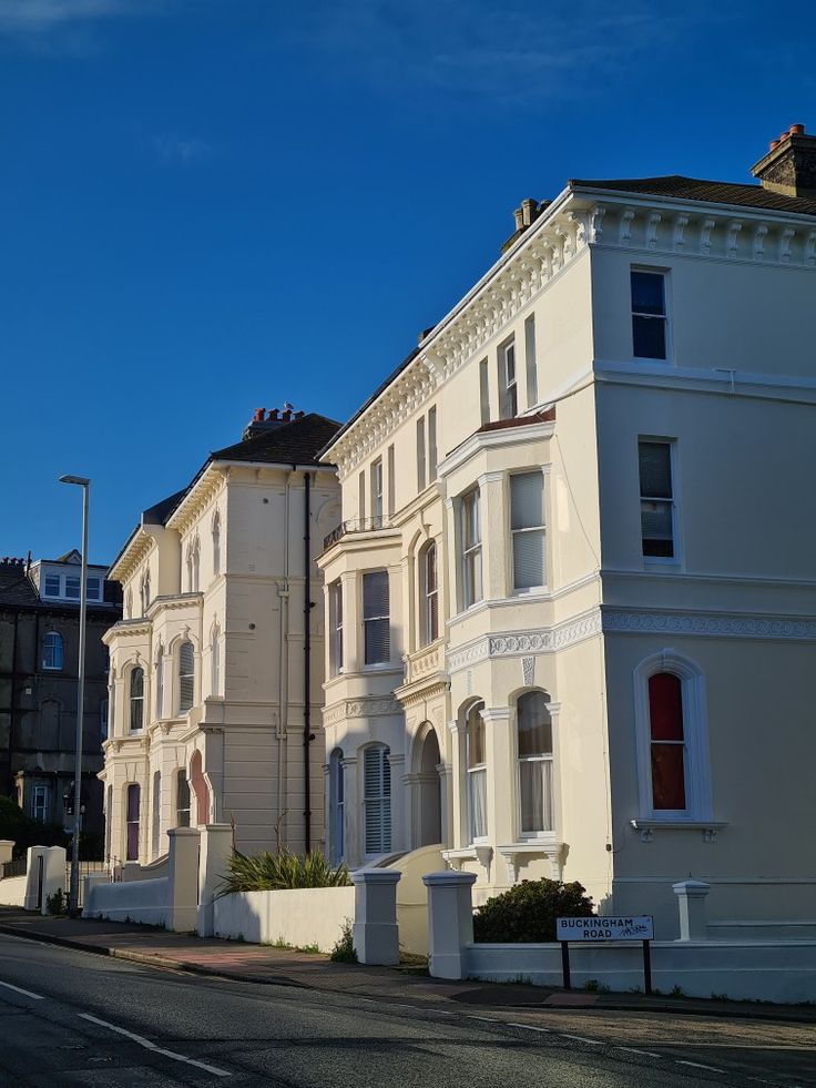 a row of white houses sitting on the side of a road