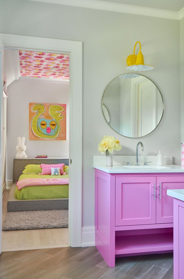 a bathroom with pink and green furniture in it