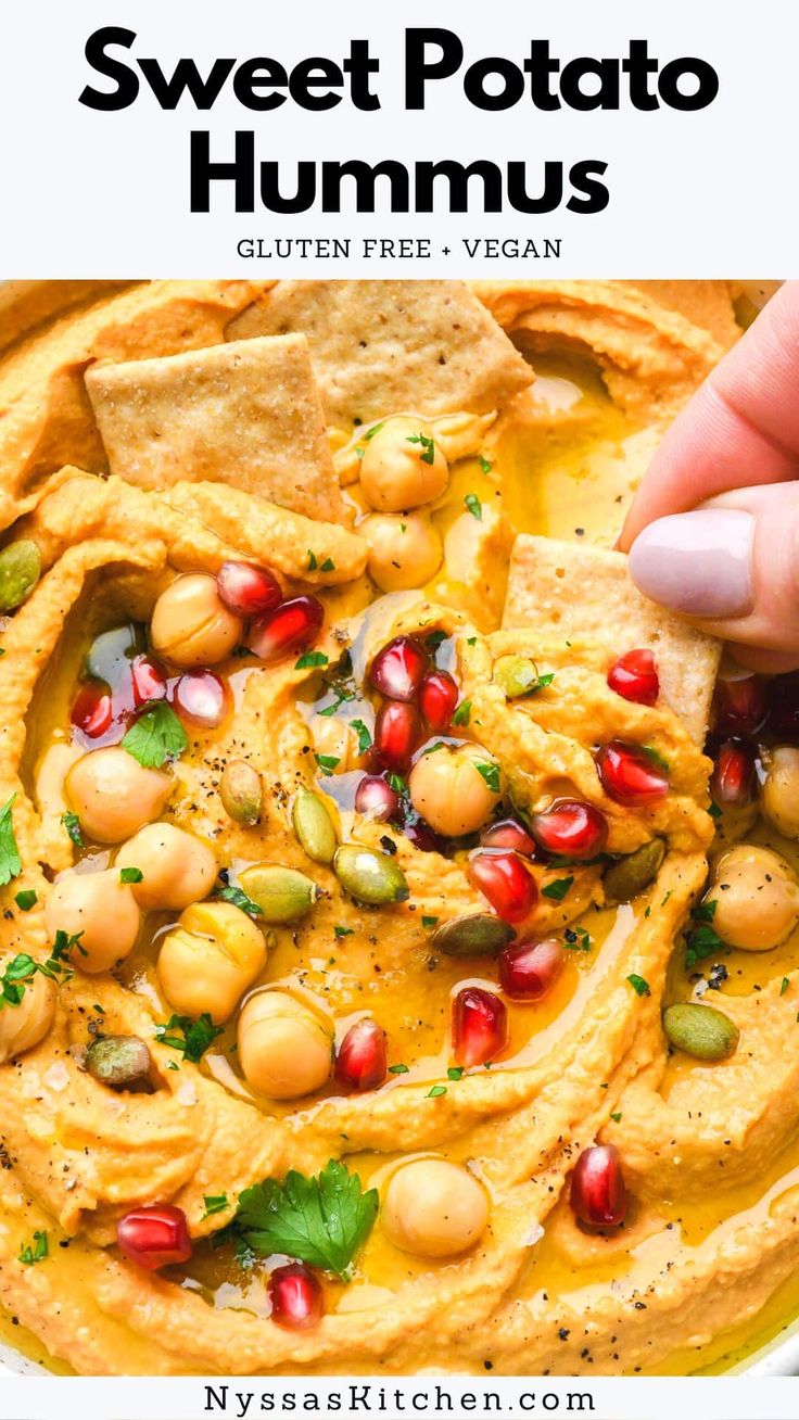 a bowl filled with hummusa and garnished with pomegranates