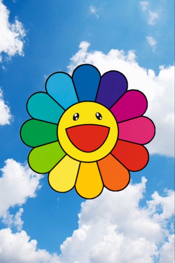 a colorful kite flying in the sky with clouds behind it and a smiley face on top